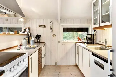 a kitchen with white cabinets and a sink at BL353-Blokhus-Kragebak-1 in Blokhus