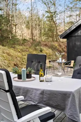 a table with a bottle of wine and two glasses at BL353-Blokhus-Kragebak-1 in Blokhus