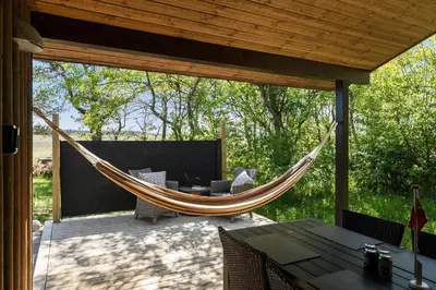 a hammock on a screened in porch with a table at BL245-Pandrup-Bremersvej-4 in Pandrup