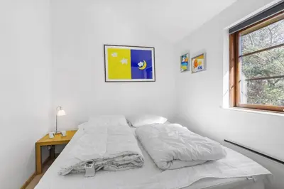 a bedroom with a bed with white sheets and a window at BL245-Pandrup-Bremersvej-4 in Pandrup