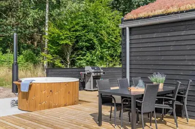 a patio with a table and chairs and a grill at BL1465-Blokhus-Bag-Hojen-8-c in Blokhus