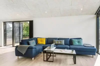 a living room with a blue couch and a table at BL1465-Blokhus-Bag-Hojen-8-c in Blokhus
