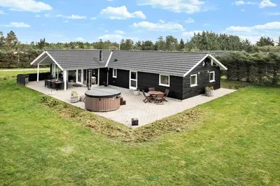 a black cottage with a patio and a grill at BL1785-Blokhus-Jaegerensvej-18 in Blokhus