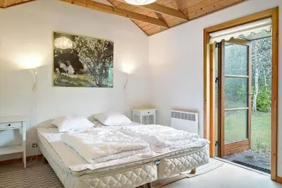 a bedroom with a bed and a picture on the wall at BL1553-Pandrup-Lunekrogen-9 in Pandrup