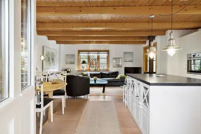 a kitchen and living room with a table and a couch at BL1553-Pandrup-Lunekrogen-9 in Pandrup