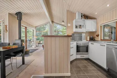 a kitchen with white cabinets and a piano in a house at BL455-Pandrup-Rodhus-Skolevej-52 in Pandrup