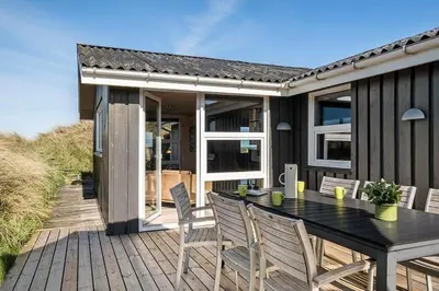 a house with a table and chairs on a deck at BL678-Saltum-Lemmingvej-10 in Saltum