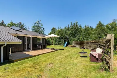 a backyard with a house with a wooden deck at BL1370-Saltum-Fladen-Grund-14 in Saltum
