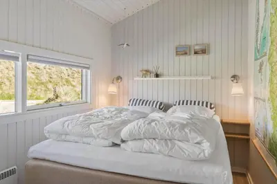 a bedroom with a bed with white sheets and a window at BL1383-Saltum-Foraarsvangen-18 in Saltum