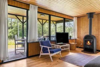 a living room with a fireplace and a tv at BL1208-Saltum-Tippen-10 in Saltum