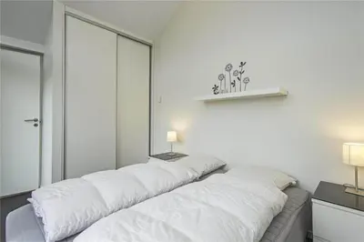 a row of white pillows on a bed in a room at BL655-Blokhus-Sdr-Strandvej-11 in Blokhus