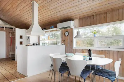a kitchen and dining room with a white table and chairs at BL1329-Blokhus-Pirupshvarrevej-67 in Blokhus