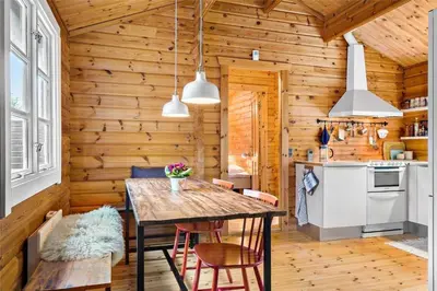 a kitchen with a table and chairs in a cabin at BL1610-Blokhus-Soren-Petersvej-20 in Blokhus