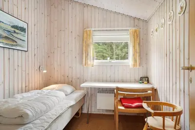 a bedroom with a bed and a table and a window at BL1394-Pandrup-Tunen-2 in Pandrup