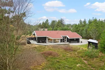 a house with a red roof in a field at BL1259-Blokhus-Bag-Hojen-83 in Blokhus