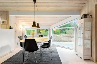 a dining room with a table and black chairs at BL1259-Blokhus-Bag-Hojen-83 in Blokhus