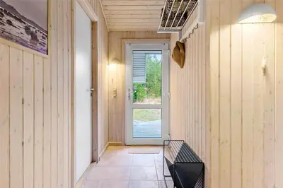 a hallway with a bench in front of a door at BL1259-Blokhus-Bag-Hojen-83 in Blokhus