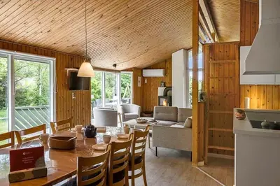 a kitchen and living room with a table and chairs at BL433-Blokhus-Raappenmark-8 in Blokhus