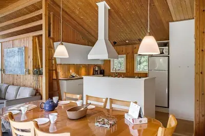 a kitchen and dining room with a table and chairs at BL433-Blokhus-Raappenmark-8 in Blokhus
