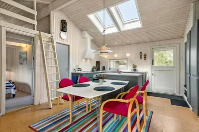 a kitchen and dining room with a table and chairs at BL173-Blokhus-Bloksbjerg-88 in Blokhus
