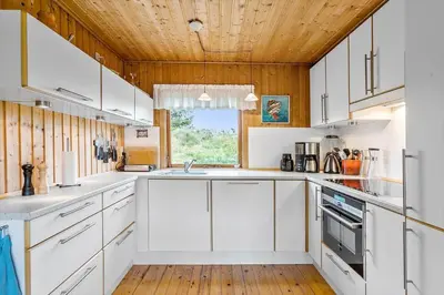 a kitchen with white cabinets and a wooden ceiling at BL1568-Saltum-P-Ejerstedgaardsvej-1-A in Saltum