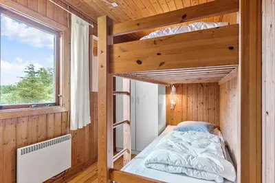 a bunk bed in a wooden room with a window at BL1568-Saltum-P-Ejerstedgaardsvej-1-A in Saltum