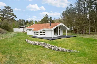 a small white house in the middle of a yard at BL1624-Blokhus-Jaegerbakken-1 in Blokhus