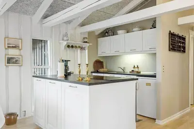 a kitchen with white cabinets and a black counter top at BL1271-Blokhus-Axel-P-Jensenvej-3 in Blokhus