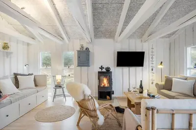 a living room with a couch and a fireplace at BL1271-Blokhus-Axel-P-Jensenvej-3 in Blokhus