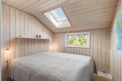 a bedroom with a bed in a room with a window at BL1272-Pandrup-Kirkekrogen-7 in Pandrup