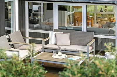 a patio with a couch and a table on a porch at BL123-Blokhus-Nonnestien-8 in Blokhus