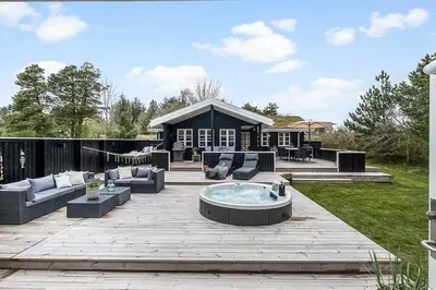 a patio with a hot tub in the middle of a yard at BL1280-Blokhus-Bloksbjerg-50 in Blokhus