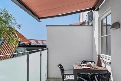 a patio with a table and chairs on a balcony at BL1287-Blokhus-Klitgaardsvej-3-A-1-2 in Blokhus