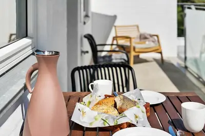 a table with a plate of bread and a vase at BL1287-Blokhus-Klitgaardsvej-3-A-1-2 in Blokhus