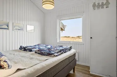 a bedroom with a bed with pillows and a window at BL1173-20-Pandrup-Hunetorp-Klitvej-119 in Pandrup