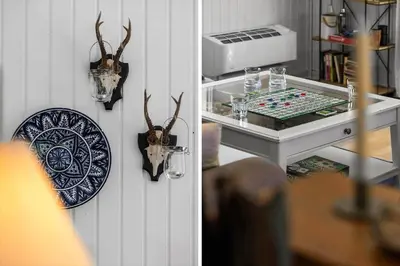 a table and a plate with antlers on a wall at BL1101-Pandrup-Rodhusparken-56 in Pandrup