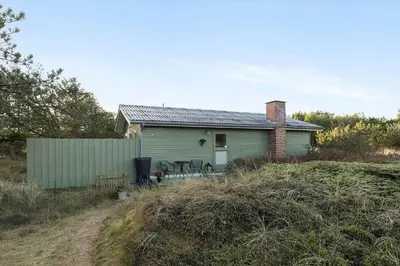 a small green house with chairs in front of it at BL1523-Saltum-Skanderborgvej-14 in Saltum