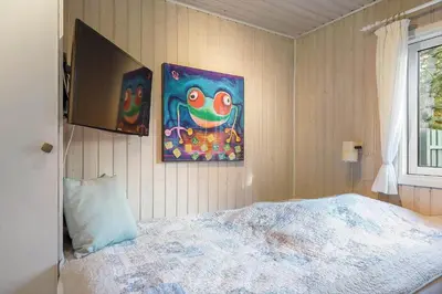 a bedroom with a bed and two paintings on the wall at BL1523-Saltum-Skanderborgvej-14 in Saltum