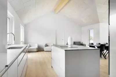 a white kitchen with white cabinets and a table at BL1108-Saltum-Vesterhavs-Sletten-45 in Saltum