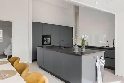 a kitchen with a counter with a sink and chairs at BL1295-Saltum-Vesterhavs-Sletten-39 in Saltum