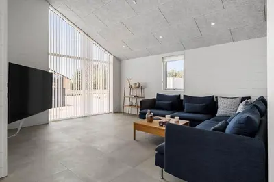 a living room with a blue couch and a tv at BL1295-Saltum-Vesterhavs-Sletten-39 in Saltum