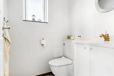 a white bathroom with a toilet and a sink at BL1310-Blokhus-Moreavej-33-A in Blokhus