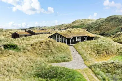 a house in the middle of a grassy hill at BL271-Blokhus-Taarnfalkevej-15 in Blokhus