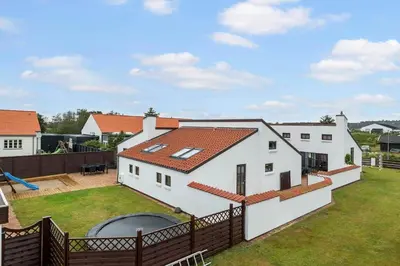 a white house with a large yard with a fence at BL1117-Blokhus-Peter-Andersensvej-10 in Blokhus