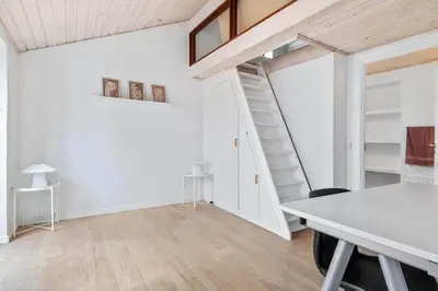 a white room with a table and a staircase at BL1117-Blokhus-Peter-Andersensvej-10 in Blokhus