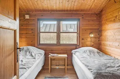 two beds in a wooden room with a window at G151-Lemvig-Porsevej-51 in Lemvig