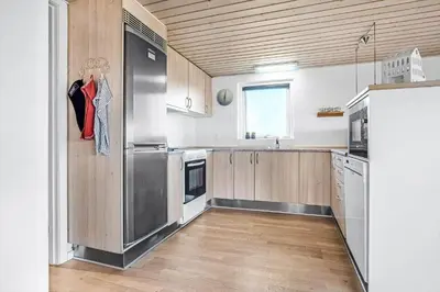 a kitchen with a stainless steel refrigerator and wooden cabinets at G430-Lemvig-Myntevej-30 in Lemvig
