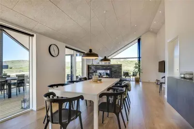 a dining room and living room with a table and chairs at 340-Harboore-Byskovvej-40 in Harboør