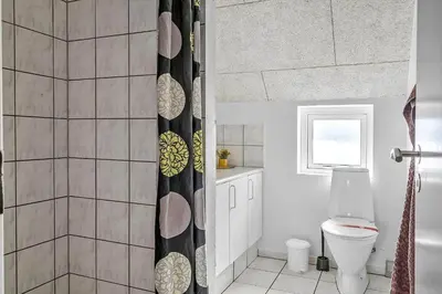 a bathroom with a toilet and a shower curtain at 159-Harboore-Alkajavej-6 in Harboør