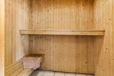 a sauna with a wooden wall with a shelf at 159-Harboore-Alkajavej-6 in Harboør